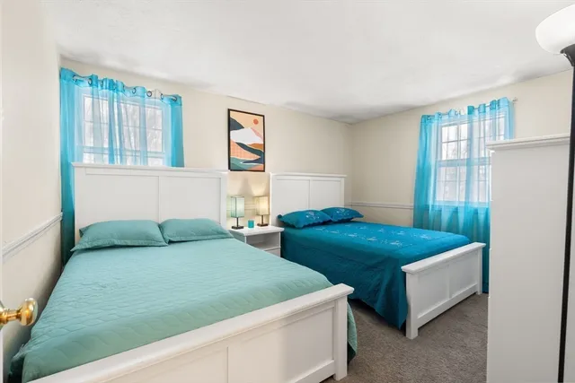 a bedroom with two beds and windows