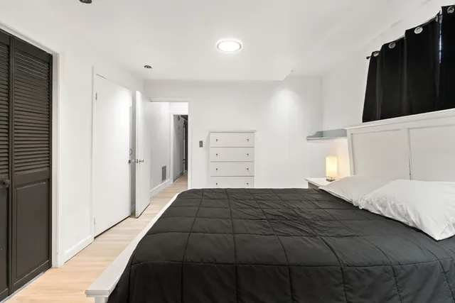 a bedroom with a bed and a black walk in closet