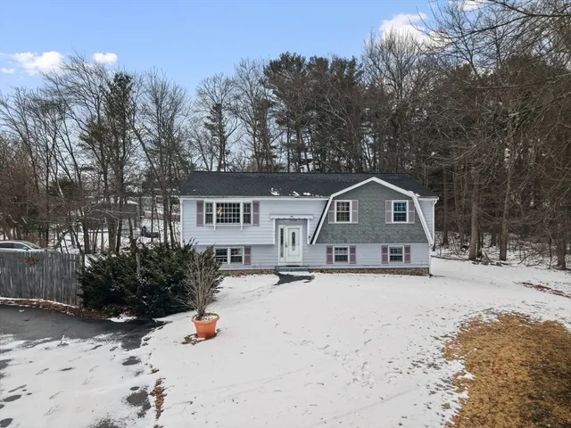 a front view of a house with a yard covered in snow