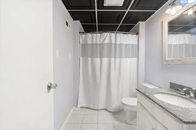 a bathroom with a granite countertop sink toilet and shower