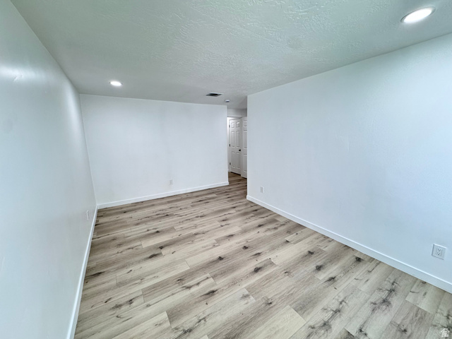 12339 Remy Road, Unit 422 Herriman, UT 84096 - Photo 36 of 36 Unfurnished room featuring light wood finished floors, a textured ceiling, and recessed lighting