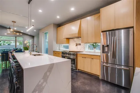 a kitchen with stainless steel appliances a refrigerator sink and stove