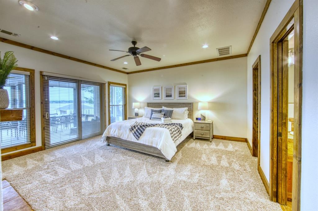6207 Point Lavista Malakoff, TX 75148 - Photo 12 of 40 a bedroom with a large bed and a chandelier