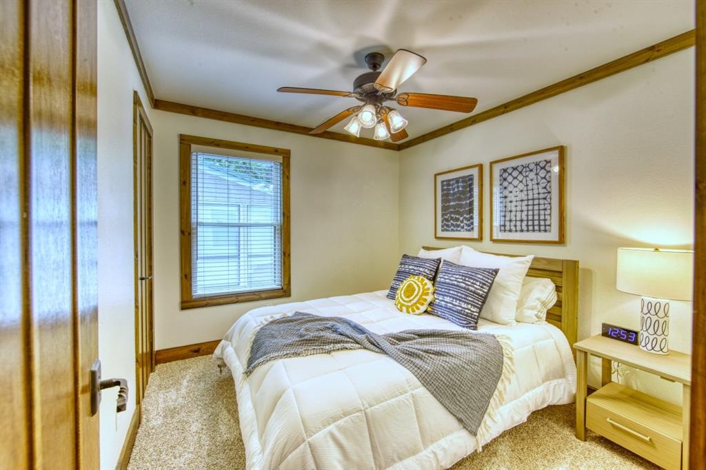 6207 Point Lavista Malakoff, TX 75148 - Photo 22 of 40 a bedroom with a bed and a chandelier