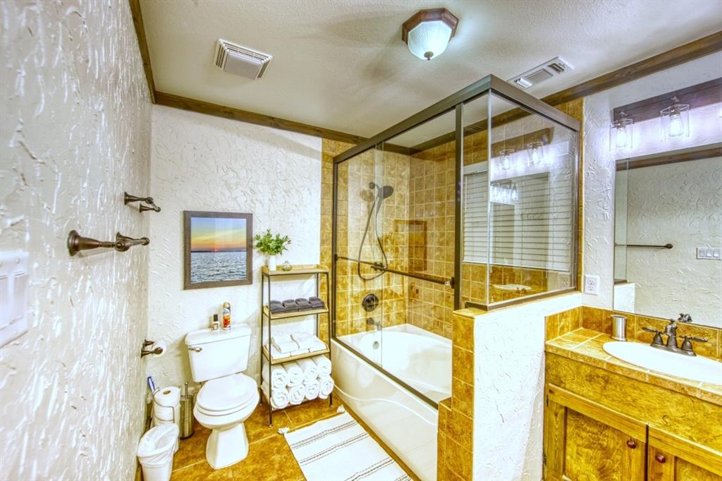 6207 Point Lavista Malakoff, TX 75148 - Photo 24 of 40 a bathroom with a granite countertop sink mirror vanity bathtub and toilet