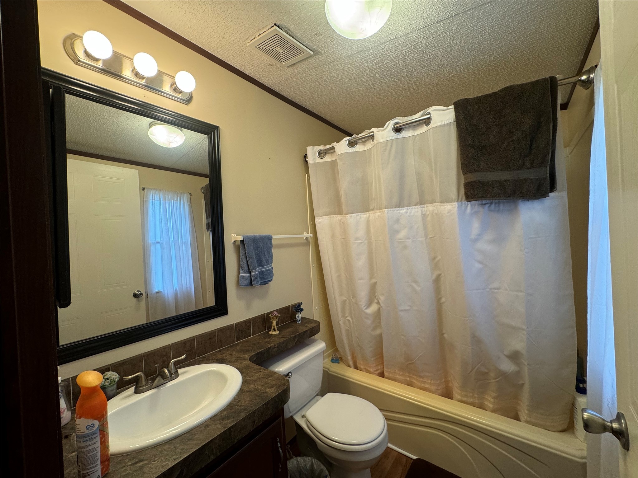 18 Mockingbird Trinity, TX 75862 - Photo 25 of 30 a bathroom with a granite countertop sink toilet a mirror a vanity and shower