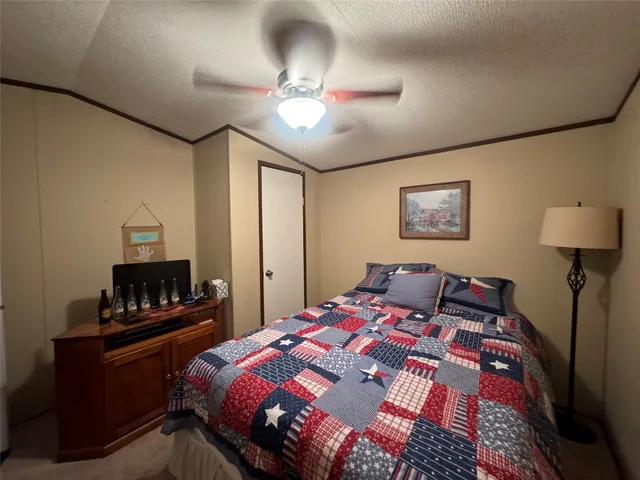 a bedroom with a bed and a lamp on dresser