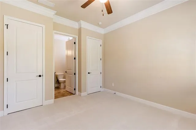 an empty room with closet and a chandelier fan