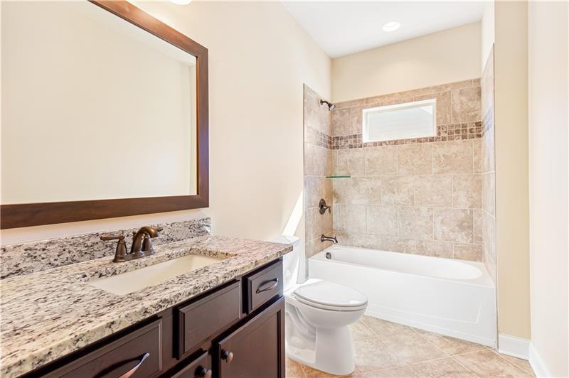 424 Loblolly Street Woodstock, GA 30188 - Photo 38 of 57 a bathroom with a granite countertop sink a toilet and shower