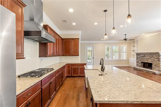 a kitchen with stainless steel appliances granite countertop a stove a sink and a wooden floors