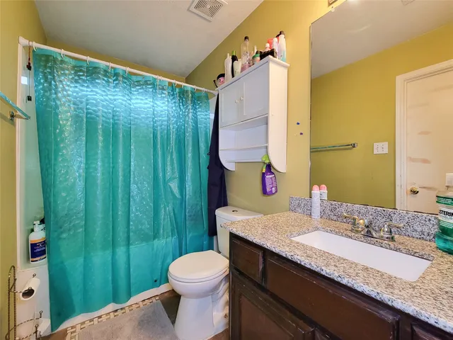 a bathroom with a granite countertop sink toilet and shower