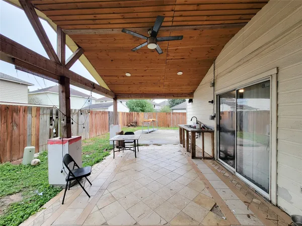 a view of a patio with table and chairs with wooden floor and fence
