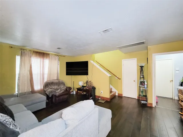 a living room with furniture flat screen tv and a large window