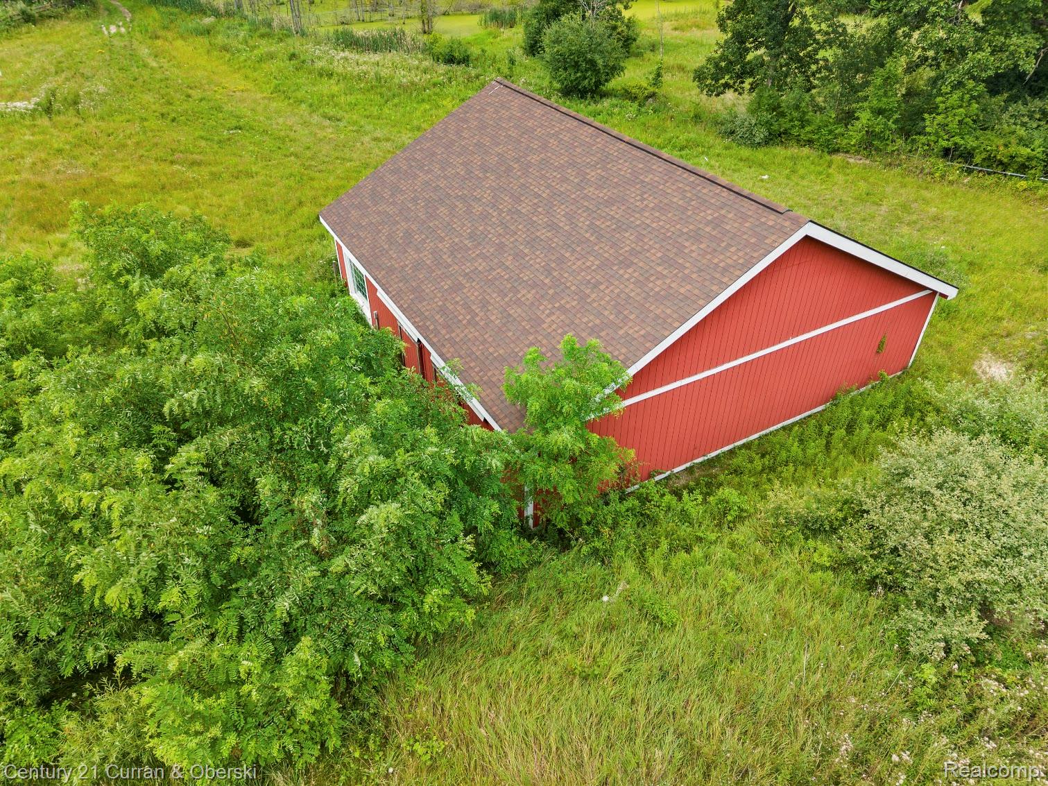 8785 Warren Road Plymouth, MI 48170 - Photo 41 of 46 Red-sided barn structure with a shingle roof, set within an expansive grassy area