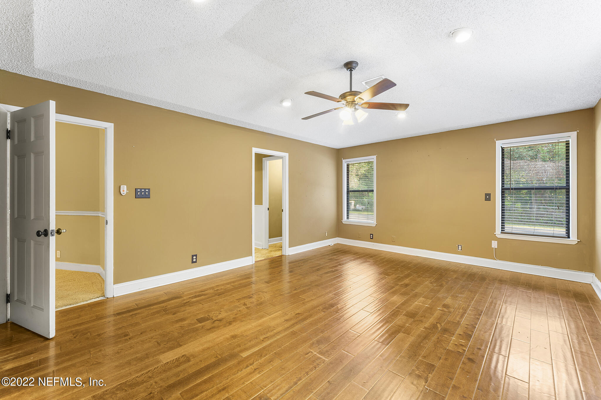 6130 Firestone Road Jacksonville, FL 32244 - Photo 21 of 67 a view of an empty room with window and wooden floor