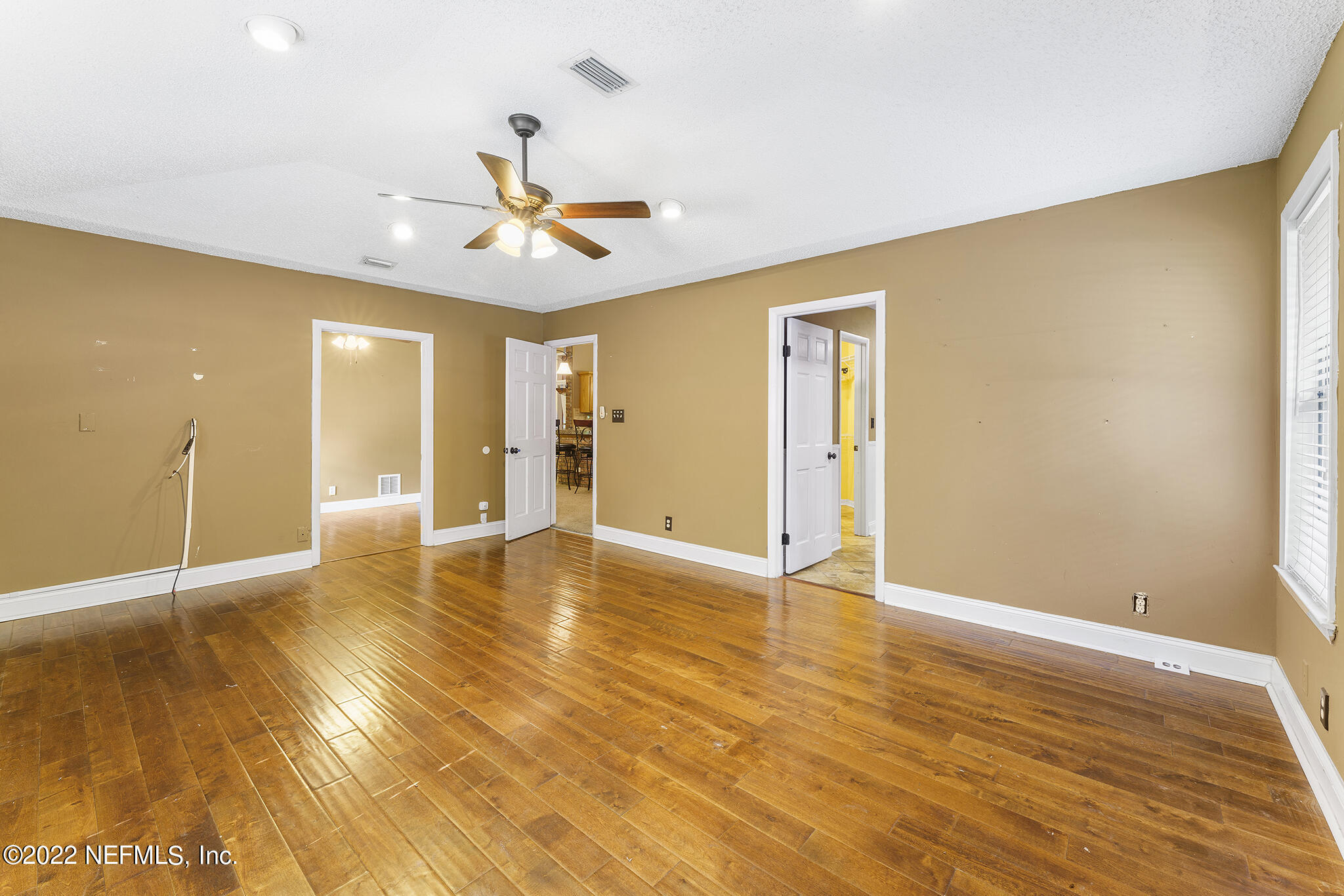 6130 Firestone Road Jacksonville, FL 32244 - Photo 39 of 67 a view of an empty room with window and wooden floor