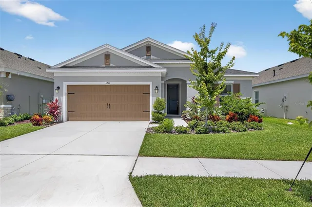 a front view of a house with a garden and plants