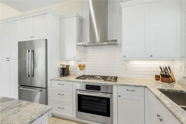 a kitchen with refrigerator a stove a sink and cabinets
