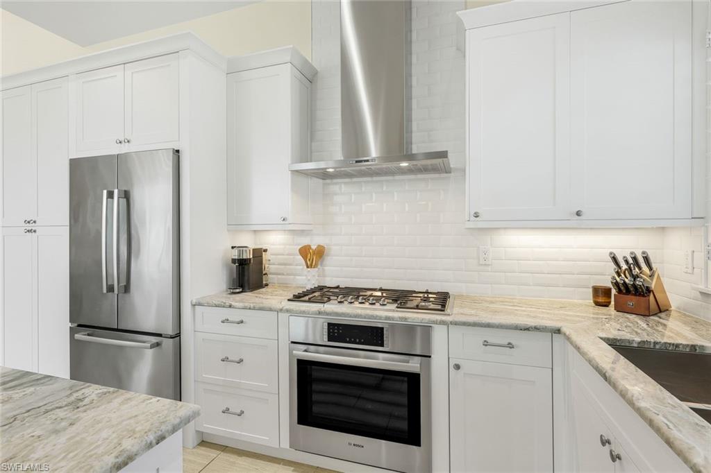 9161 Mercato Way Naples, FL 34108 - Photo 13 of 50 a kitchen with refrigerator a stove a sink and cabinets