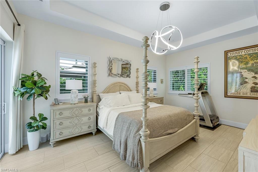 9161 Mercato Way Naples, FL 34108 - Photo 14 of 50 a bedroom with a bed and a chandelier