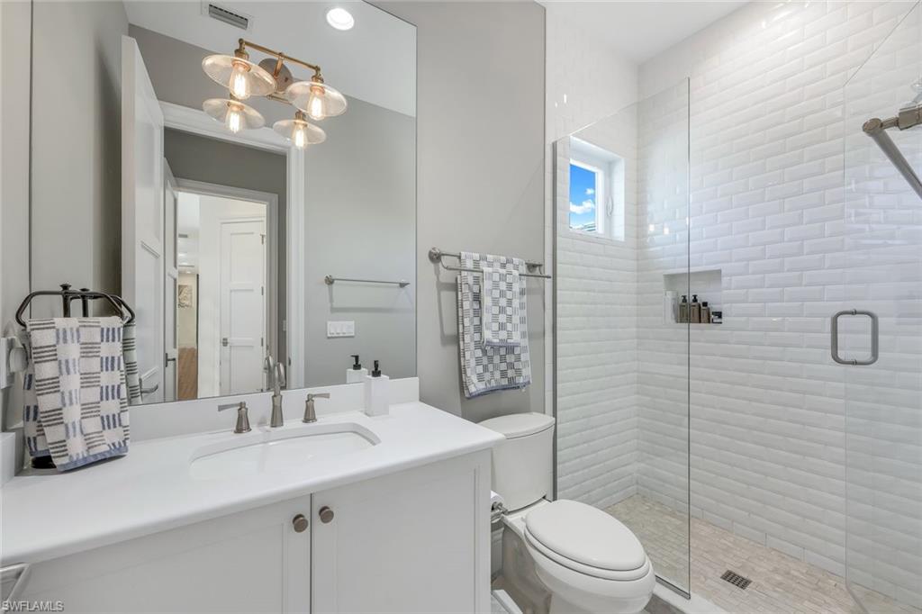 9161 Mercato Way Naples, FL 34108 - Photo 31 of 50 a bathroom with a toilet sink and mirror