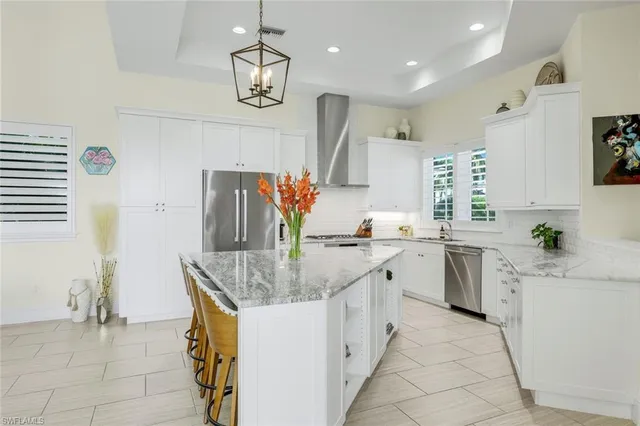 a kitchen with stainless steel appliances granite countertop a sink dishwasher stove refrigerator and cabinets