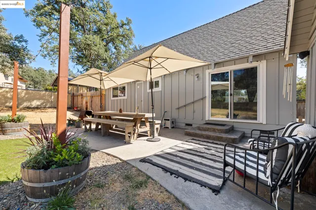 a backyard of a house with table and chairs