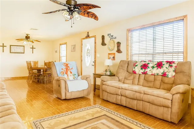 a living room with furniture a flat screen tv and a window