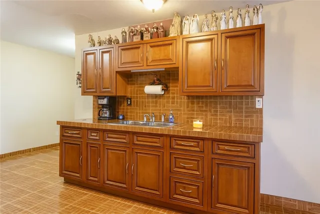 a dining hall with stainless steel appliances granite countertop a stove a sink a dining table and chairs with wooden floor