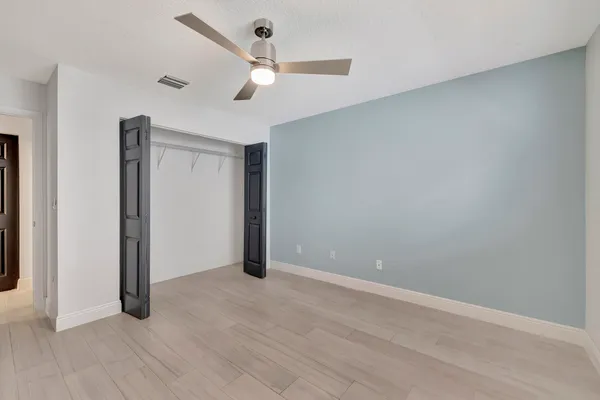 an empty room with a window and ceiling fan