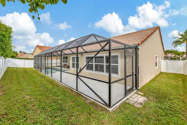 a view of a swimming pool with a yard and plants