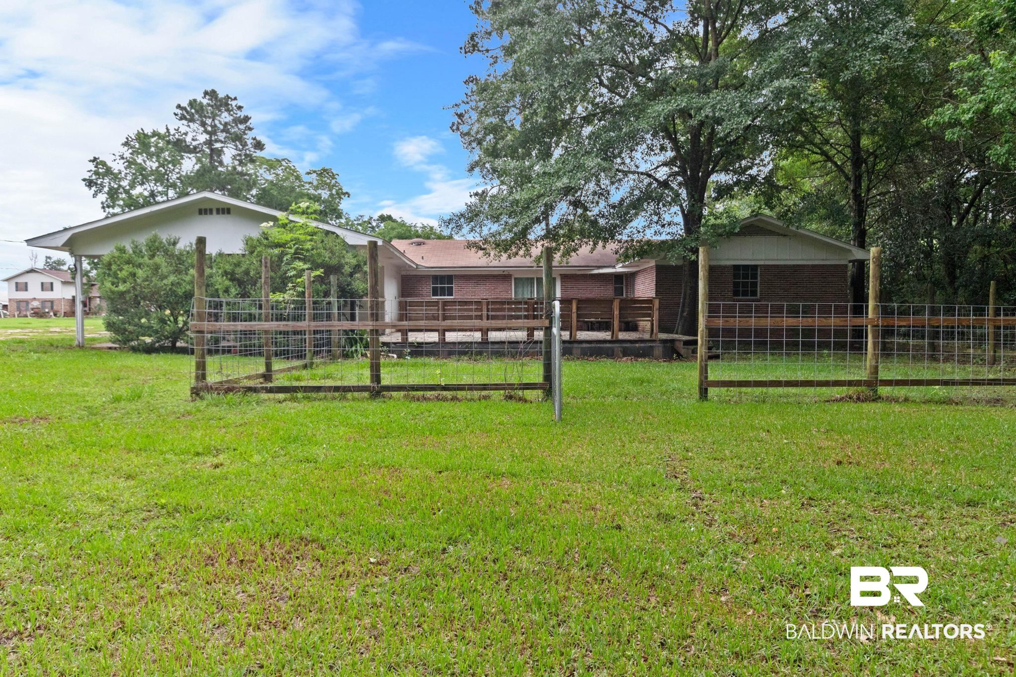 384 Old Bratt Road Atmore, AL 36502 - Photo 56 of 64 Expansive rear yard featuring green lawn, partial fencing, and mature trees