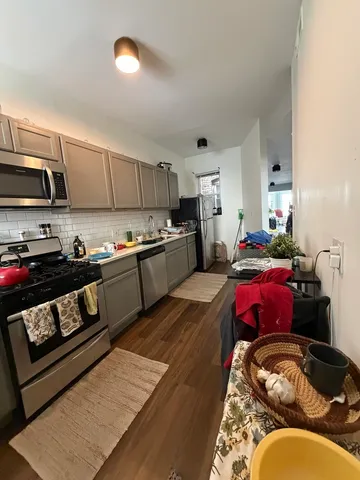 a kitchen with stainless steel appliances granite countertop a stove refrigerator and cabinets