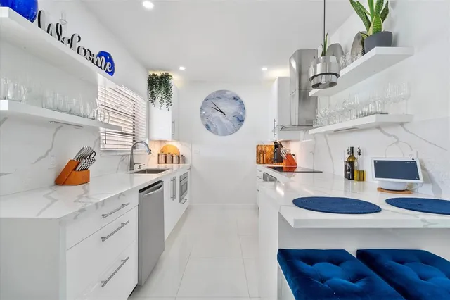 a kitchen with white cabinets and clock