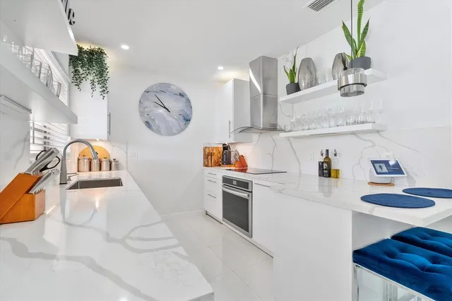 a kitchen with granite countertop a sink a stove and cabinets