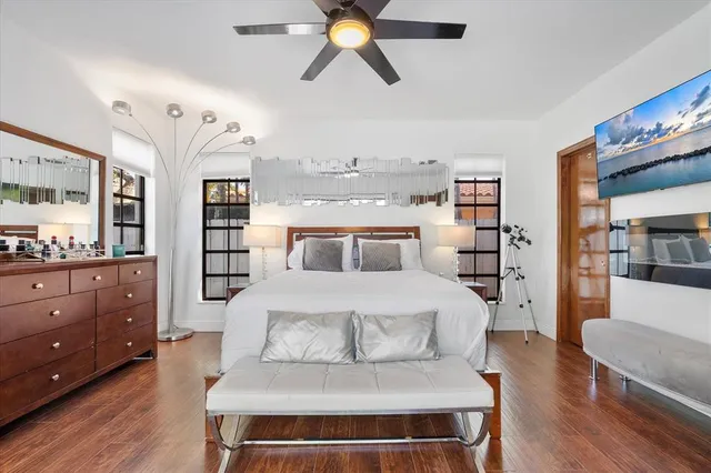 a bedroom with a large bed and a chandelier
