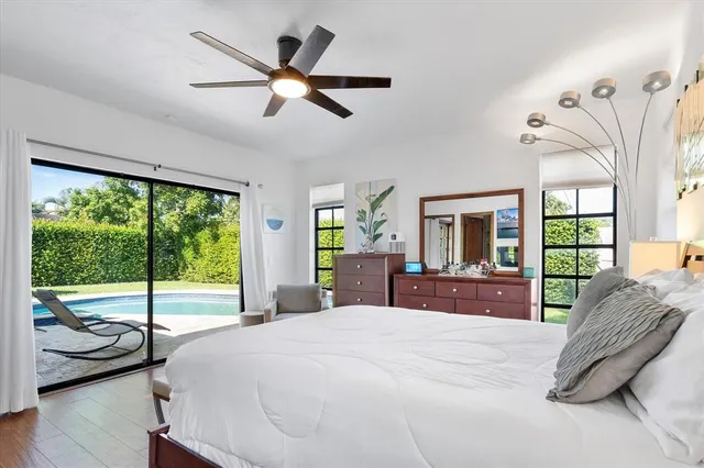a bedroom with a bed and large windows