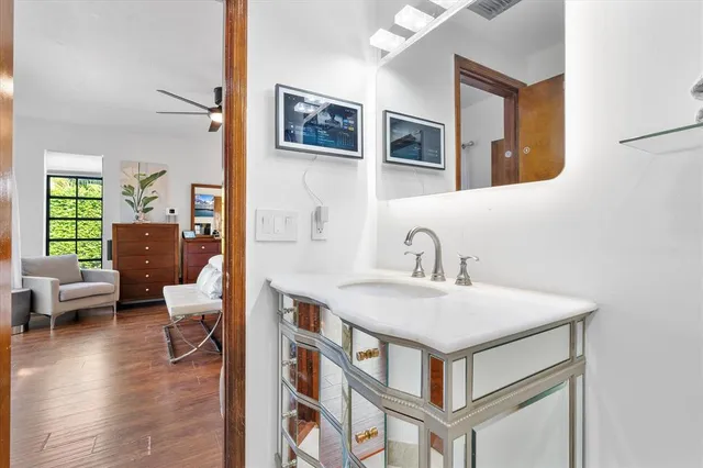 a bathroom with a sink a toilet and a large mirror