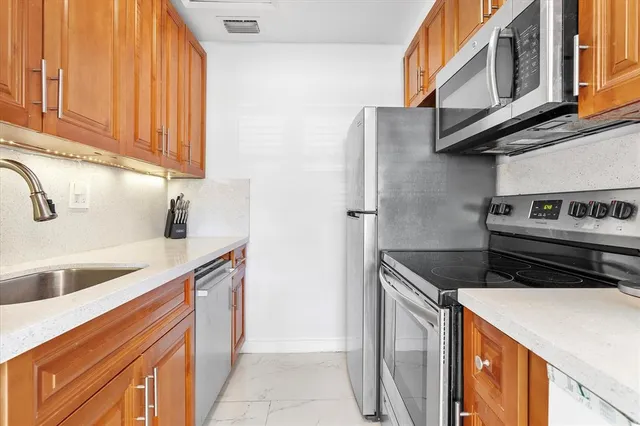 a kitchen with stainless steel appliances granite countertop a sink and a stove