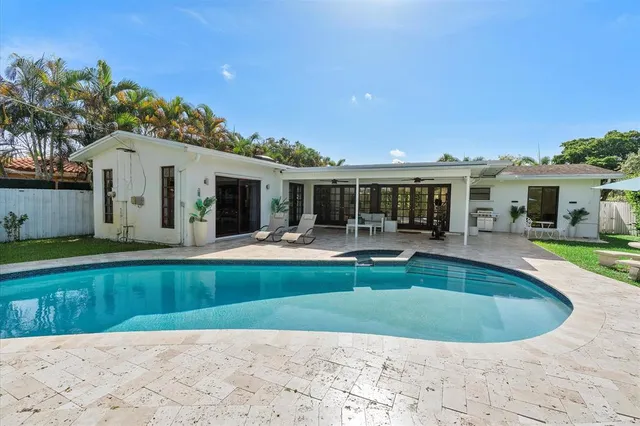 a view of a house with a swimming pool and a yard