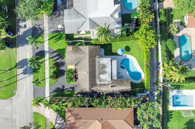 an aerial view of a house with a yard and large trees