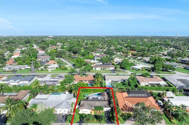 an aerial view of a city with lots of residential buildings and ocean view in back