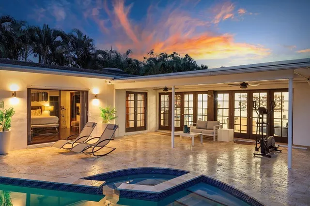 a view of a swimming pool with lounge chair in front of house