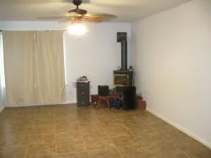 a view of an empty room with furniture and a window