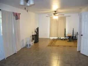 a view of a room with gym equipment and a chandelier