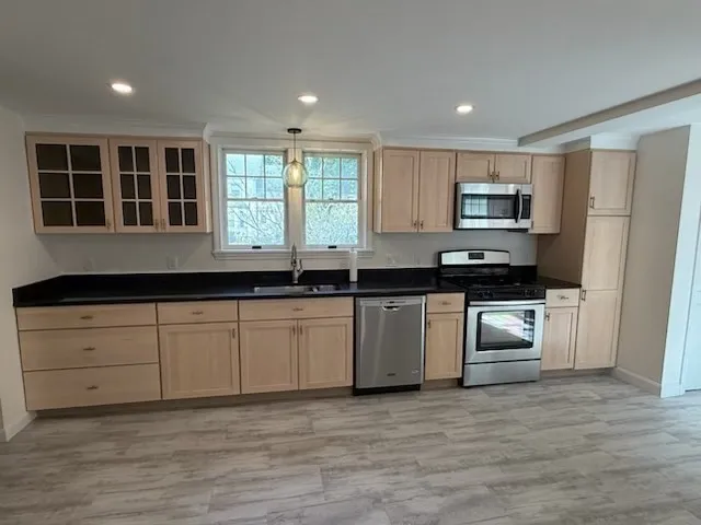 a kitchen with kitchen island granite countertop a stove a sink and a refrigerator