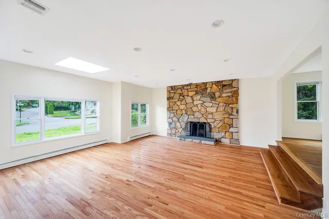 wooden floor fireplace and windows in an empty room