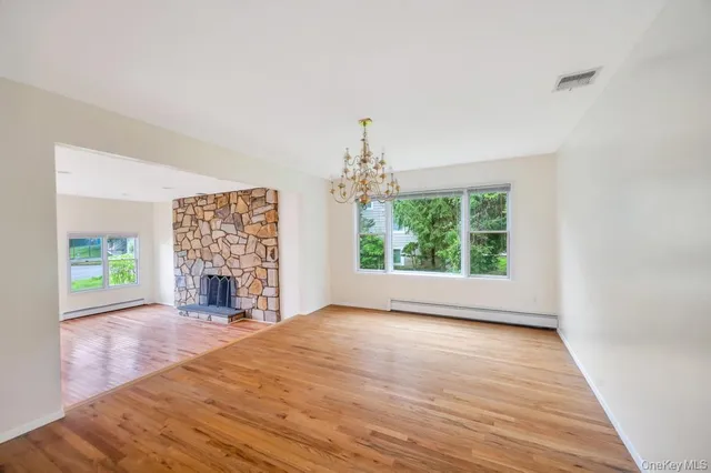 wooden floor fireplace and windows in an empty room