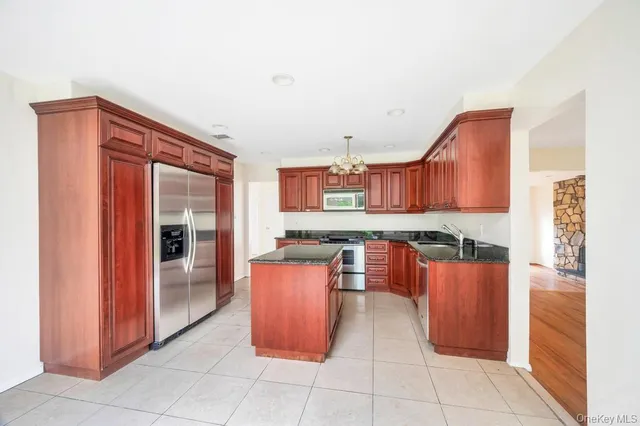 a kitchen with stainless steel appliances granite countertop a refrigerator and a stove
