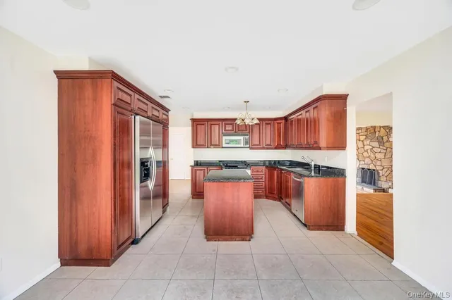 a kitchen with stainless steel appliances granite countertop a refrigerator and a stove